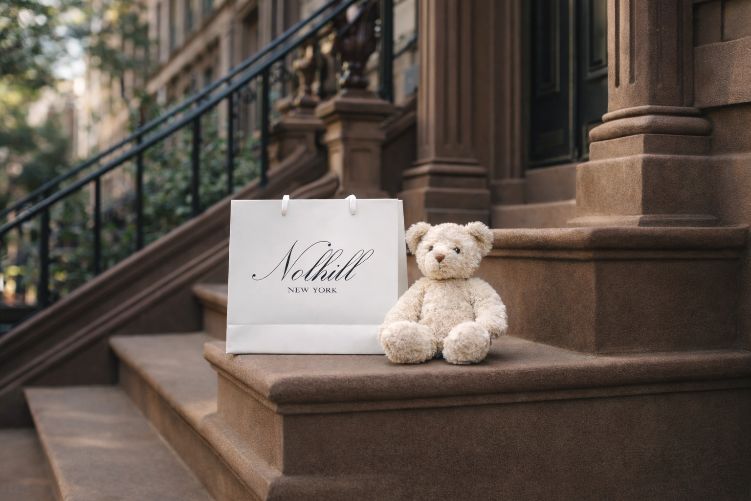 Teddy bear sitting on a brownstone staircase with a 'Nolhill' sign.