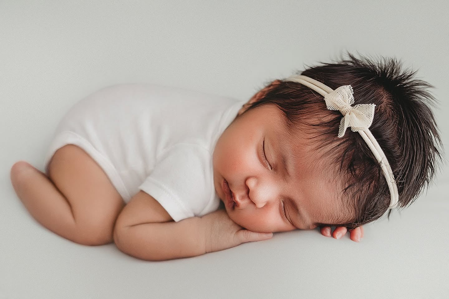 A timeless newborn session by Angi Carman highlighting the soft, breathable fit of the Nolhill Essential white Pima cotton bodysuit.