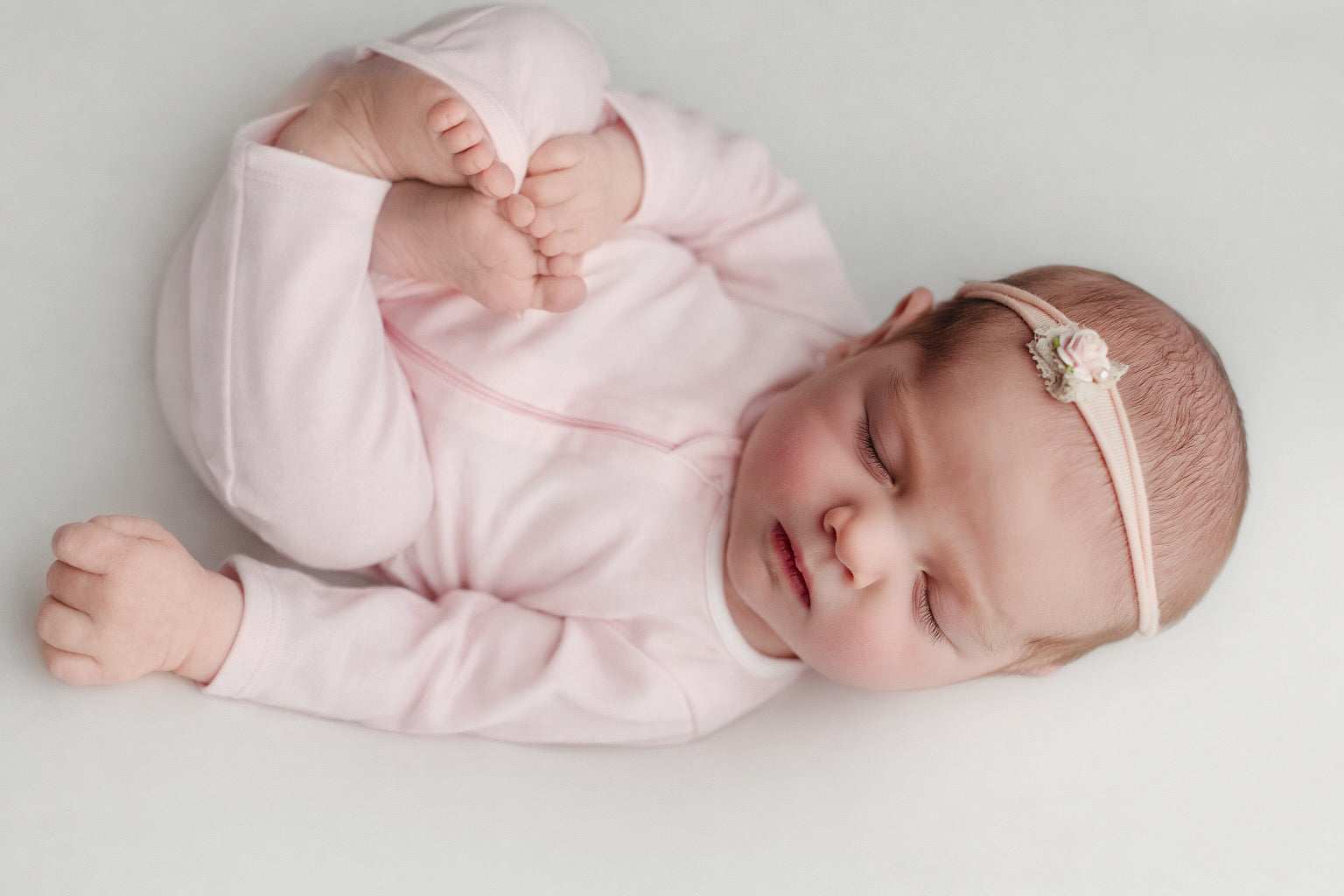 Artistic lifestyle photography by Angi Carman showcasing the Nolhill Lina footless romper in a delicate blush Pima cotton.