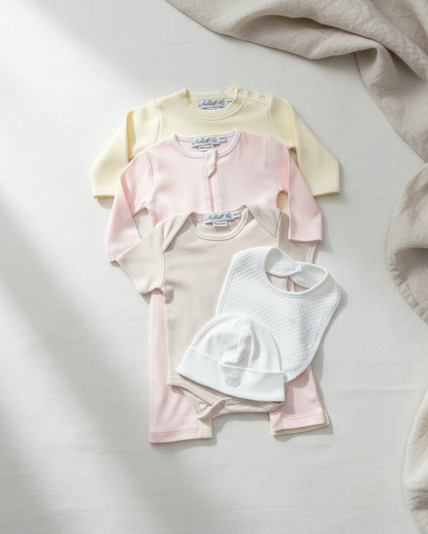 Oatmeal, Lifestyle  Nolhill Madison Girl complete newborn gift set with layette, romper, bodysuit, beanie and bib in Pima cotton