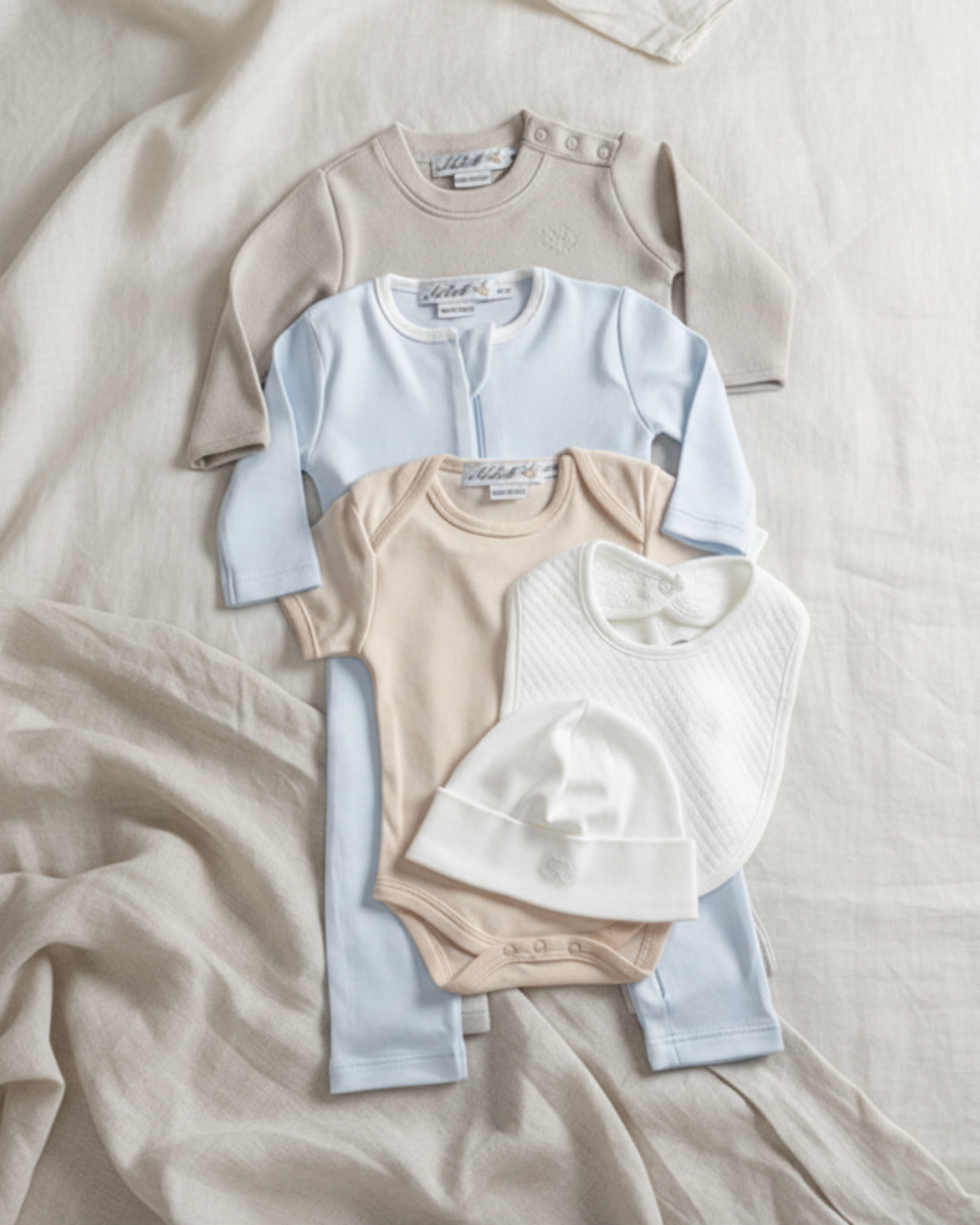 Oatmeal, Lifestyle Nolhill Madison Boy complete newborn gift set with layette, romper, bodysuit, beanie and bib in Pima cotton