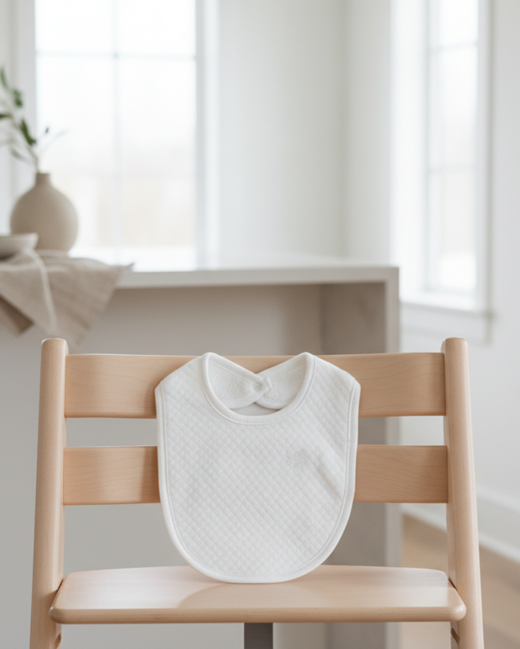 white, Lifestyle Nolhill Remy quilted bib in Pima cotton with tonal embroidery, front view 