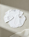 white, Lifestyle Nolhill Starter 3-piece newborn essentials set with white bodysuit, beanie and bib in Pima cotton